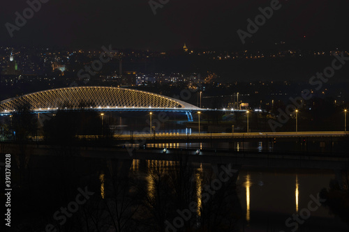  view of street lighting on bridges on the Vltava river in the city of Prague at night and lights from passing cars