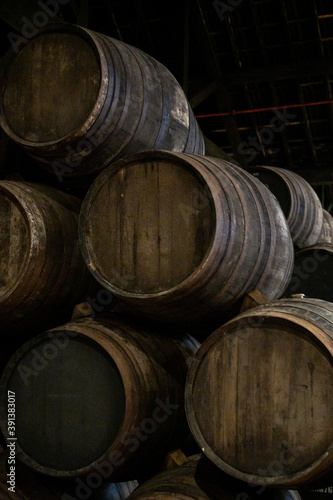 Old porto lodge with rows of oak wooden casks for slow aging of fortified ruby or tawny porto wine in Vila Nova de Gaia, Portugal