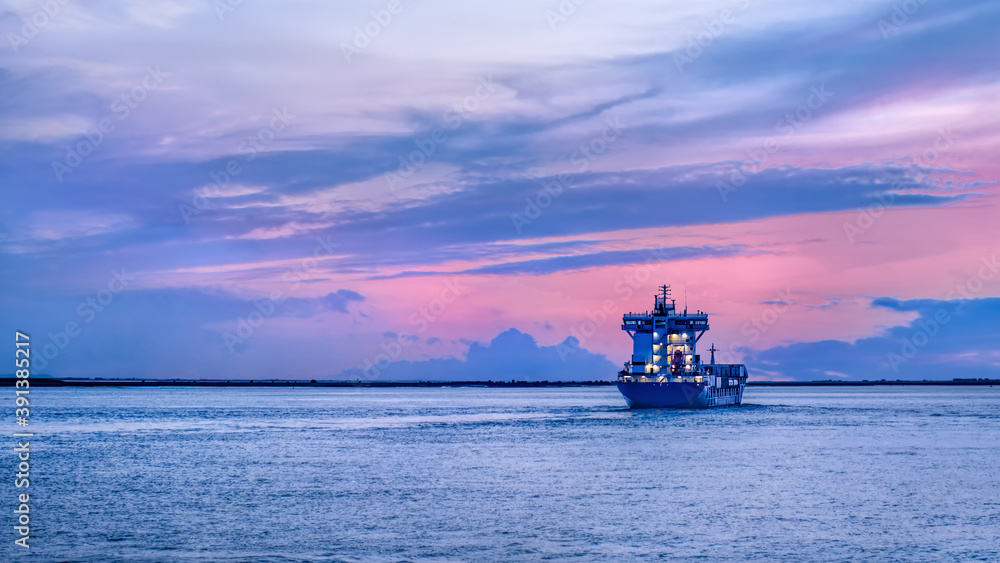 Vessel leaving Port of Antwerp during a colorful sunset, Antwerp, Flanders, Belgium.