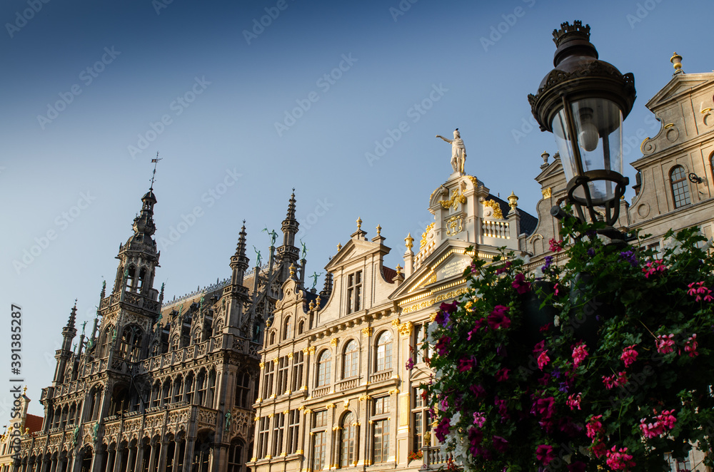 Brussels, Belgium, August 2019. The Great Square or Grote Markt. The evening light enhances its beauty of the magnificent Baroque and Gothic buildings. A lamppost decorated with a planter is the frame