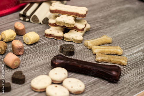 Pet food, snacks for dogs. Dog tasty colored biscuits on wooden background.