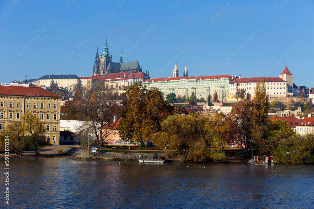 Autumn colorful Prague Lesser Town with gothic Castle above River Vltava in the sunny Day, Czech Republic