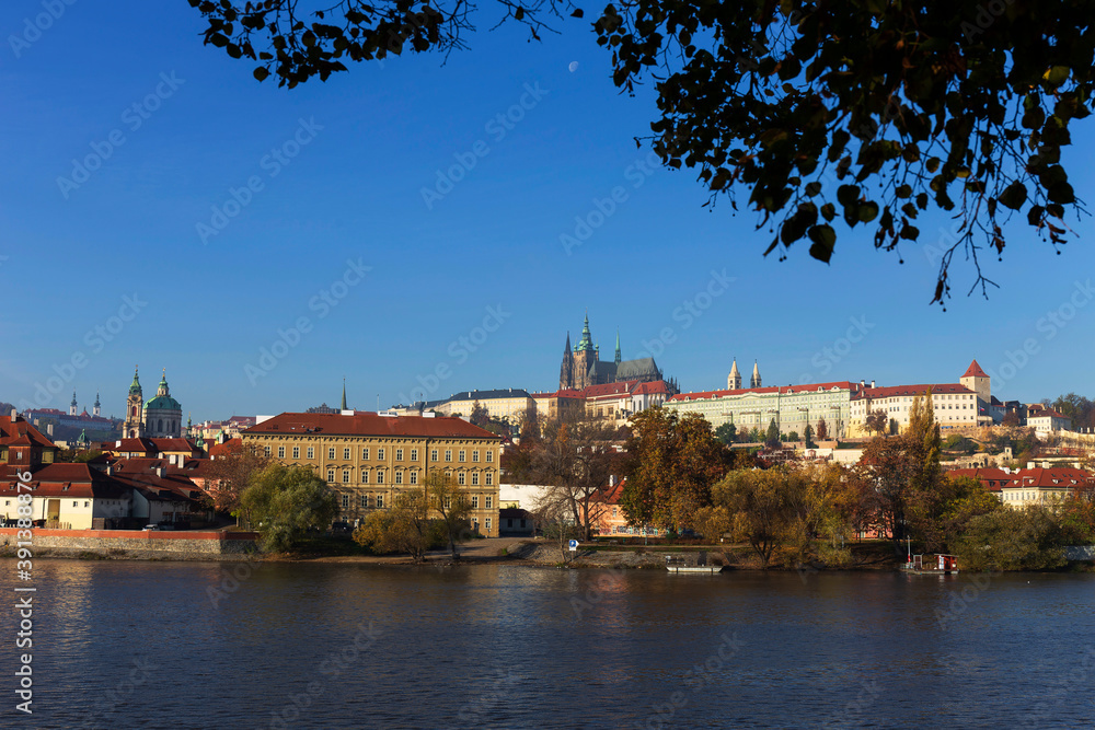 Obraz premium Autumn colorful Prague Lesser Town with gothic Castle above River Vltava in the sunny Day, Czech Republic