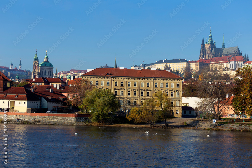Obraz premium Autumn colorful Prague Lesser Town with gothic Castle above River Vltava in the sunny Day, Czech Republic