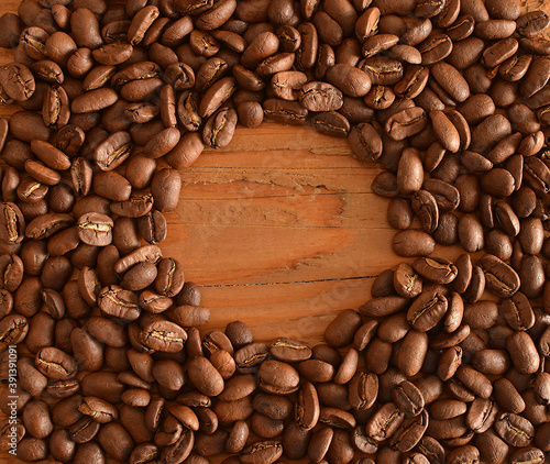 Backdrop of coffee beans round  squaer frame Empty space for inscription or object cup on old retro vintage aged wooden texture brown yellow board kitchen table backgroun photo