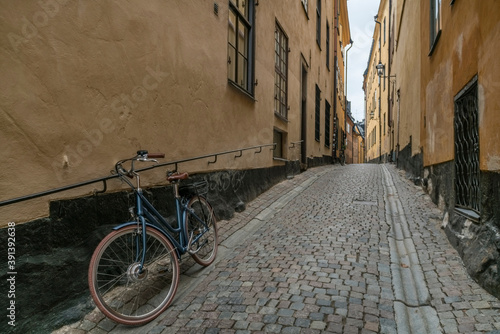 Photography bike parked in medieval street with yellow houses and coble  stones