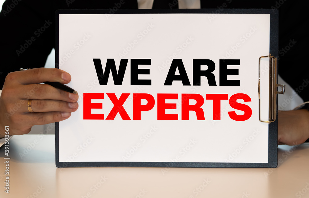Notepad with text EXPERT ADVICE on business charts and pen. Notepad with text EXPERT ADVICE on business charts and pen.