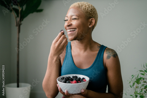 Black woman eating healthy fruit and berries photo