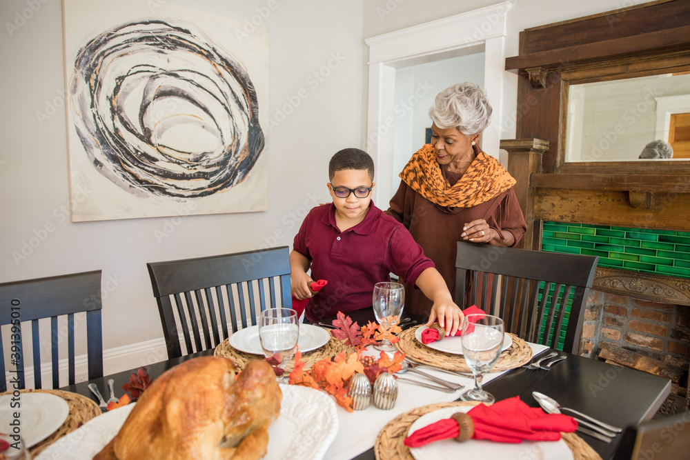 Grandmother and grandson doing Thanksgiving dinner setting Stock Photo