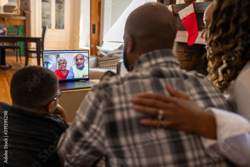 Family having a video chat  with grandparents on laptop at home for Christmas photo