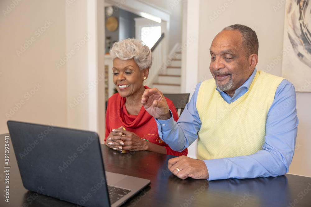 Grandmother and grandfather having a video chat on laptop at home for Christmas Grandmother and grandfather having a video chat on laptop at home for Christmas