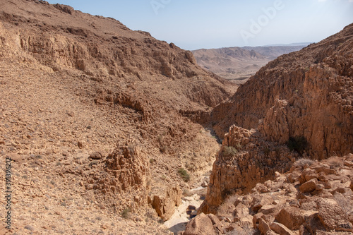 Narrow canyon of dry wadi Abuv in Judaean Desert close to city Arad, Israel. Mountain landscape with rock formations and boulders.