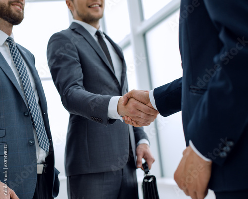 business people shaking hands while standing in the office