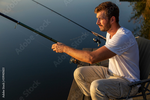 Handsome man fishing on the lake.
