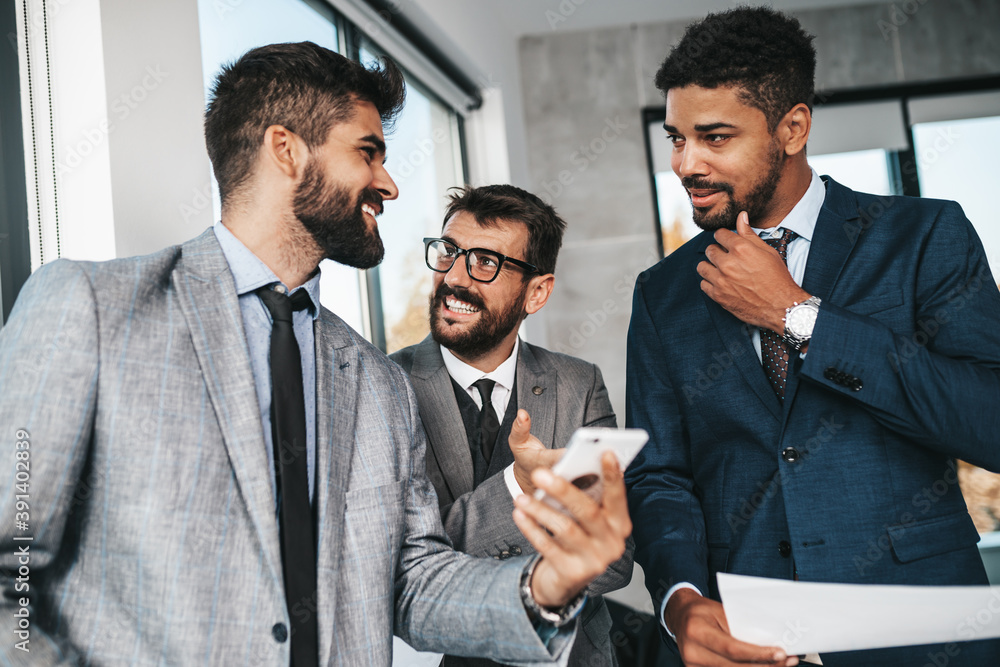 Group of businessmen working together in their office on important project. They are analyzing their business plan together. Group of businessmen working together in their office on important project. They are analyzing their business plan together.