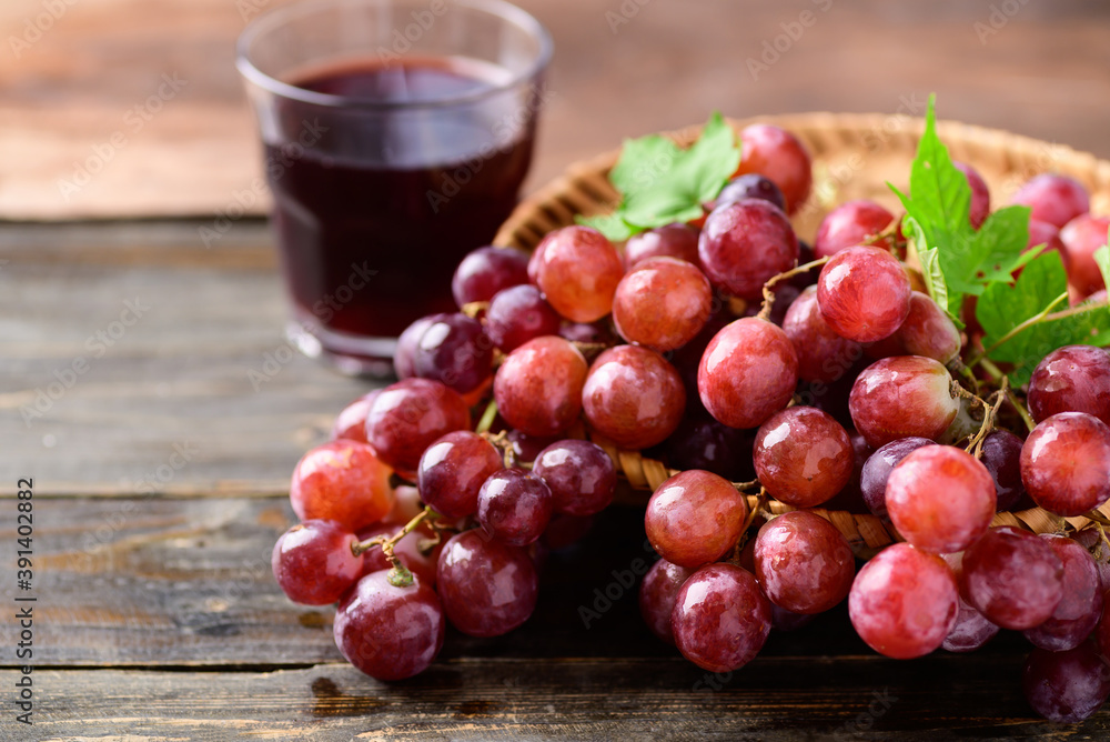 Fresh red grapes fruit and juice on wooden background Fresh red grapes fruit and juice on wooden background