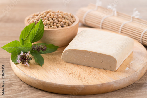 Fresh tofu and soybean seeds on wooden cutting board prepare for cooking, Asian vegan food