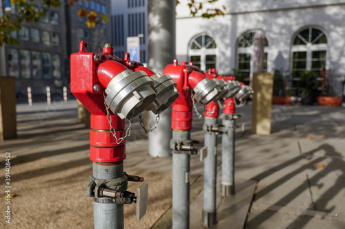 Selective focus at Red fire hydrant on sidewalk or plaza. Fire hydrant pipe and pump for fire fighting and extinguishing. photo