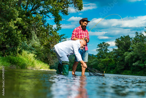 Mature man with friend fishing. Fishing as holiday. Rest and recreation. Carry on fishing. Bearded men catching fish. Happy cheerful people. I am retired. Leisure. Happy fishermen.