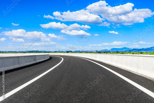 New asphalt road and green mountains with city skyline natural landscape in the city suburbs. © ABCDstock