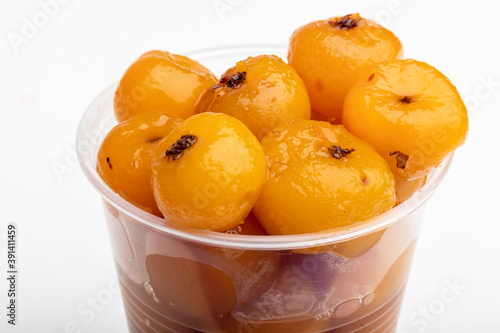 Disposable cup of tejocotes (mexican hawthorn) in heavy syrup as a dessert photo