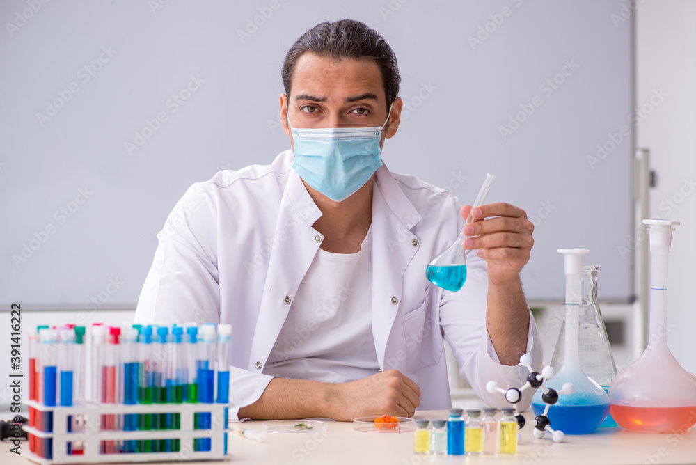 Young male chemist working in the lab Young male chemist working in the lab