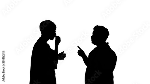 The silhouette of a man and woman talking in a serious conversation.