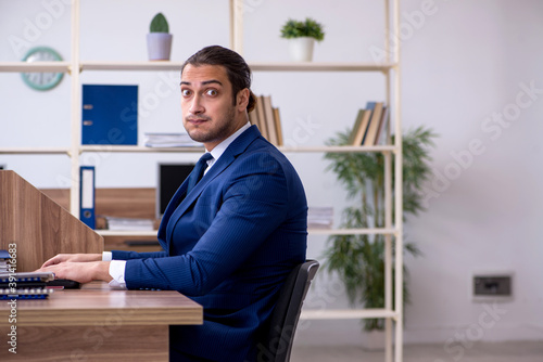 Quadro su tela Young male employee working in the office