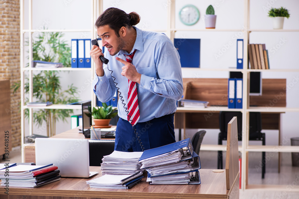 Young male employee unhappy with excessive work