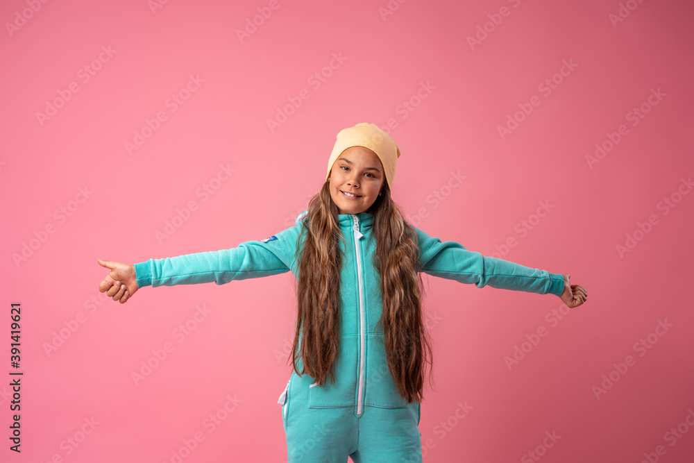 Teen girl in beanie stylish turquoise warm jumpsuit with hood and sneakers Teen girl in beanie stylish turquoise warm jumpsuit with hood and sneakers