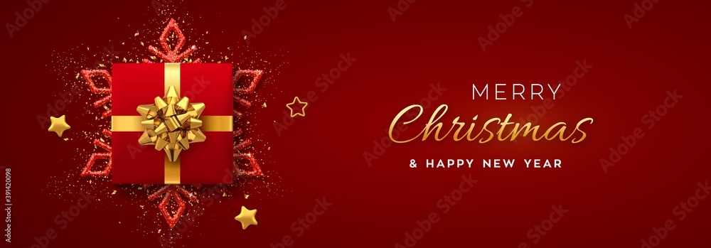 Christmas banner. Realistic red gift box with golden bow, shining snowflake, gold stars and glitter confetti. Xmas background, horizontal poster, greeting cards, headers website. Vector.