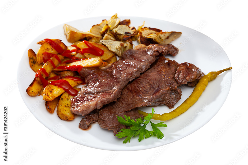 Beef cutlet with roasted potato, artichokes and marinated pepper. Isolated over white background