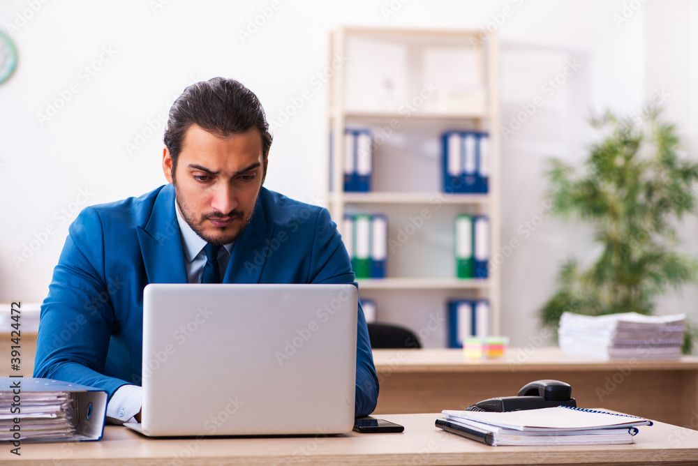 Young male employee and too many work in the office Young male employee and too many work in the office