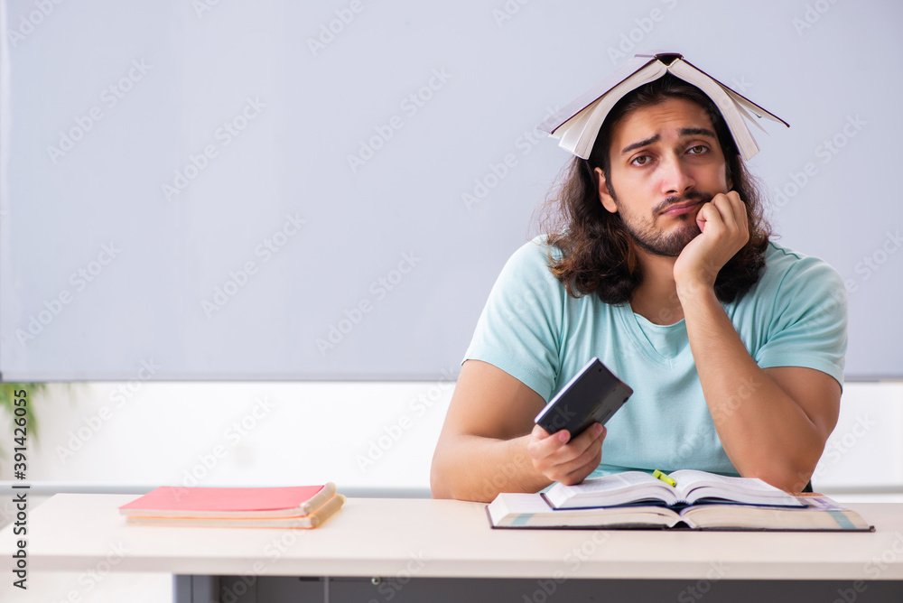 Young male student preparing for exams in the classroom Young male student preparing for exams in the classroom