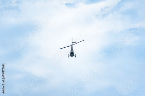 silhouette of a small helicopter flying in the sky