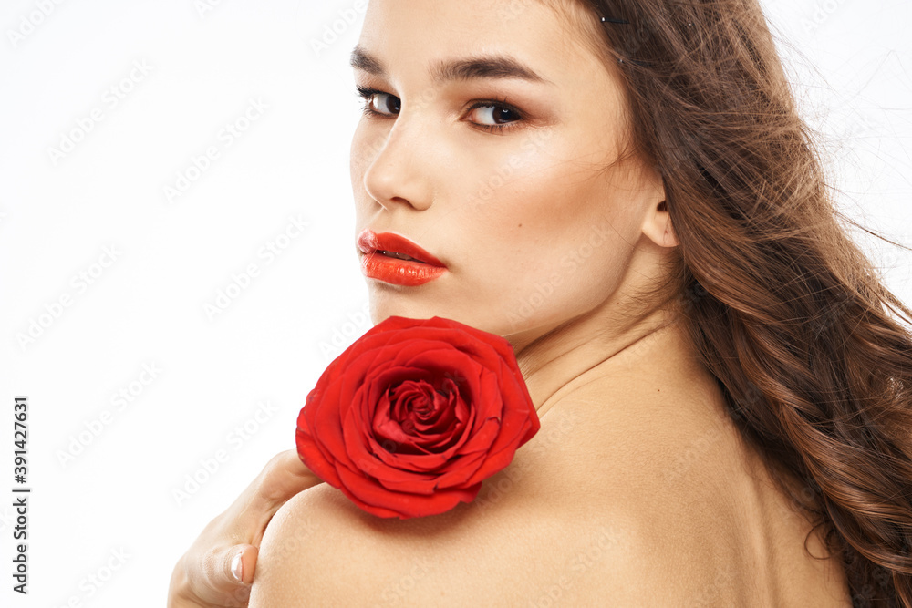 Woman with naked shoulders and red rose evening makeup light background Woman with naked shoulders and red rose evening makeup light background