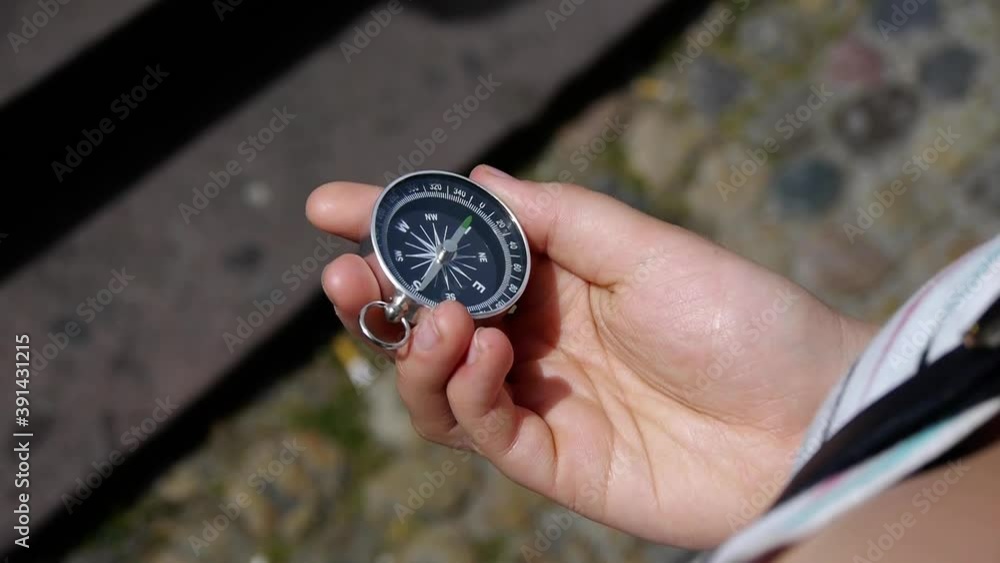 A young woman takes out a compass and holds it A young woman takes out a compass and holds it