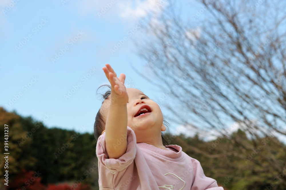 空に手を伸ばす女の子 空に手を伸ばす女の子