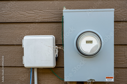 Photography Residential utility electric meter with gauge mounted on siding
