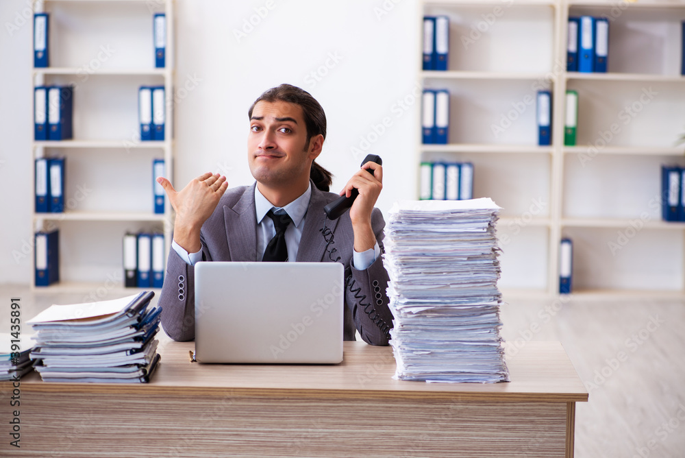 Young male employee unhappy with excessive work Young male employee unhappy with excessive work