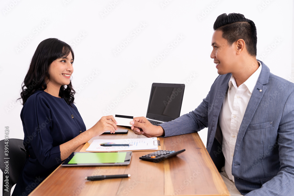 business man transactions with his credit card to a customer service woman. in the office business man transactions with his credit card to a customer service woman. in the office