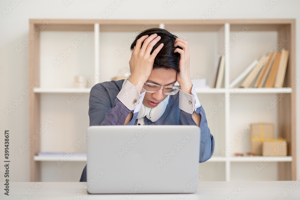 Desperate student. Exam failure. Distance learning. Online education. Frustrated stressed asian guy in glasses with laptop regrets about mistake at light workplace. Desperate student. Exam failure. Distance learning. Online education. Frustrated stressed asian guy in glasses with laptop regrets about mistake at light workplace.