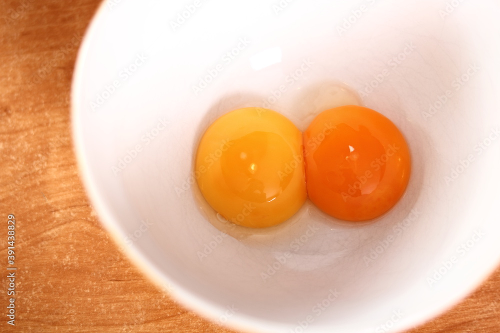 Separating egg yolk from white. Making mayonnaise with a wooden spoon. Separating egg yolk from white. Making mayonnaise with a wooden spoon.