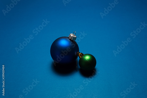 Close-up of two Christmas tree toys ornaments on background of blue color.