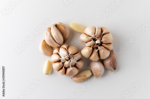 Pile of Garlic cloves and pieces of raw garlic on isolated white background. Top view Garlic bulbs with blank space.