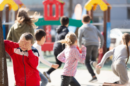 Teenage playing hide-and-go-seek in the playground. High quality photo