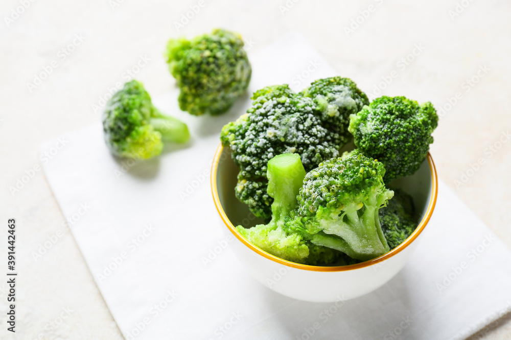 Bowl with frozen broccoli on light background Bowl with frozen broccoli on light background