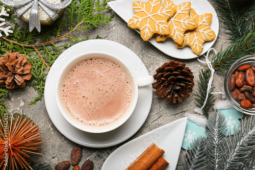 Cup of hot cacao drink with Christmas decorations and cookies on grunge background