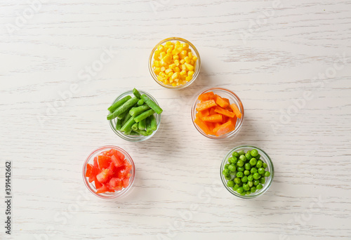 Wallpaper Mural Bowls with different frozen vegetables on white wooden background Torontodigital.ca