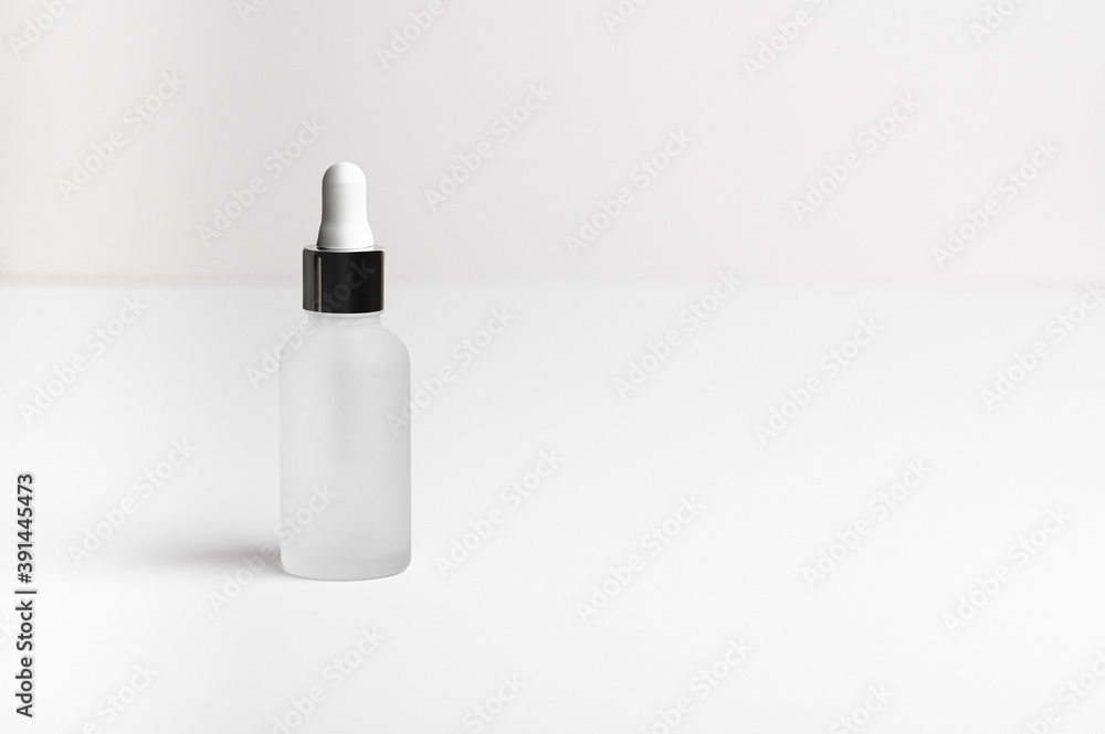 Face serum in a white glass package, bottle on a white neutral background. Natural treatment for dry skin with oils, vitamins and collagen. Packaging of cosmetic beauty product, pack shot, copy space Face serum in a white glass package, bottle on a white neutral background. Natural treatment for dry skin with oils, vitamins and collagen. Packaging of cosmetic beauty product, pack shot, copy space